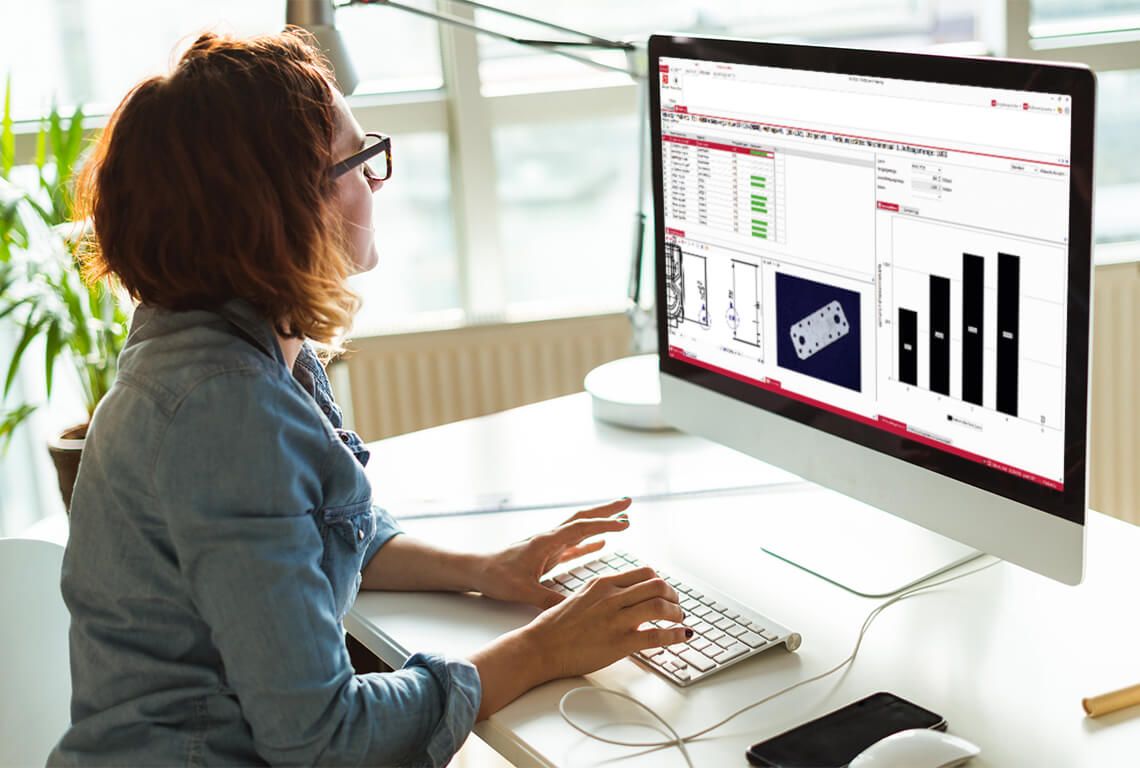 A woman enters inspection data on a computer.
