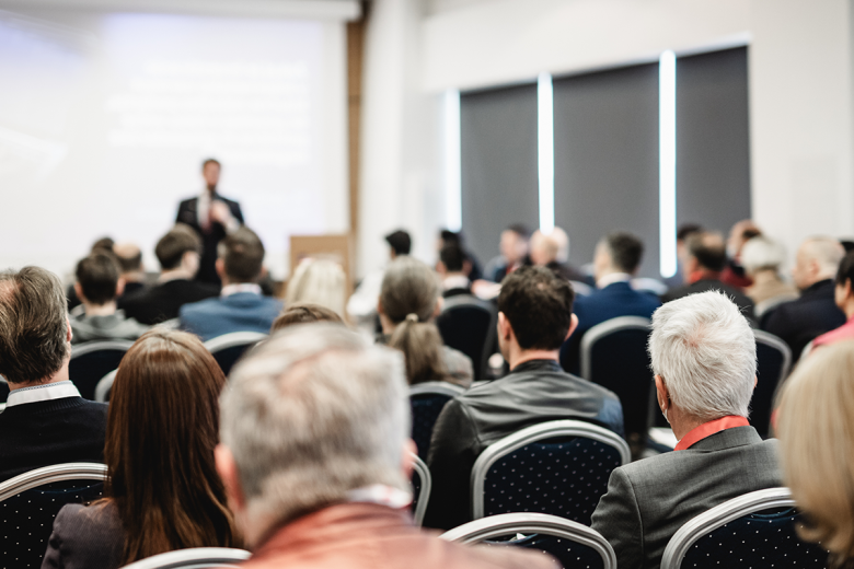 Audience attending a presentation during a professional event in a conference room