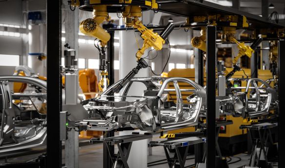 Industrial robots assembling vehicle bodies in an automated manufacturing facility